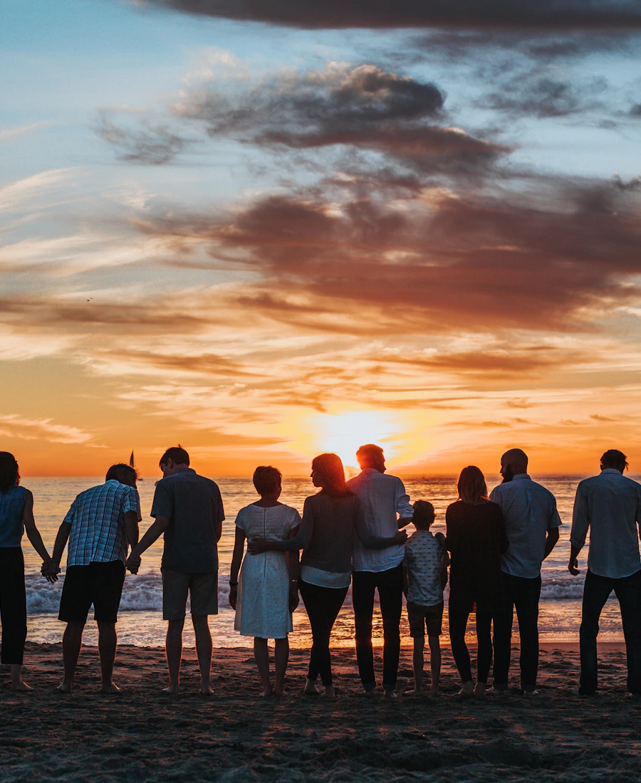 Pessoas abraçadas vendo o pôr do sol na praia
